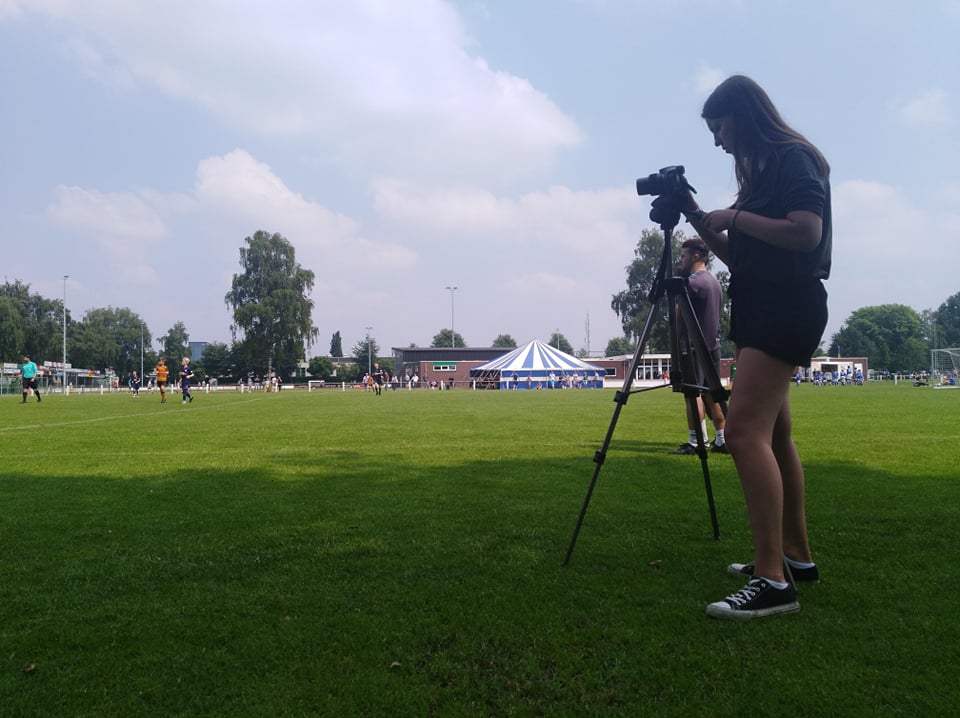 Paulina filming with a tripod in a field